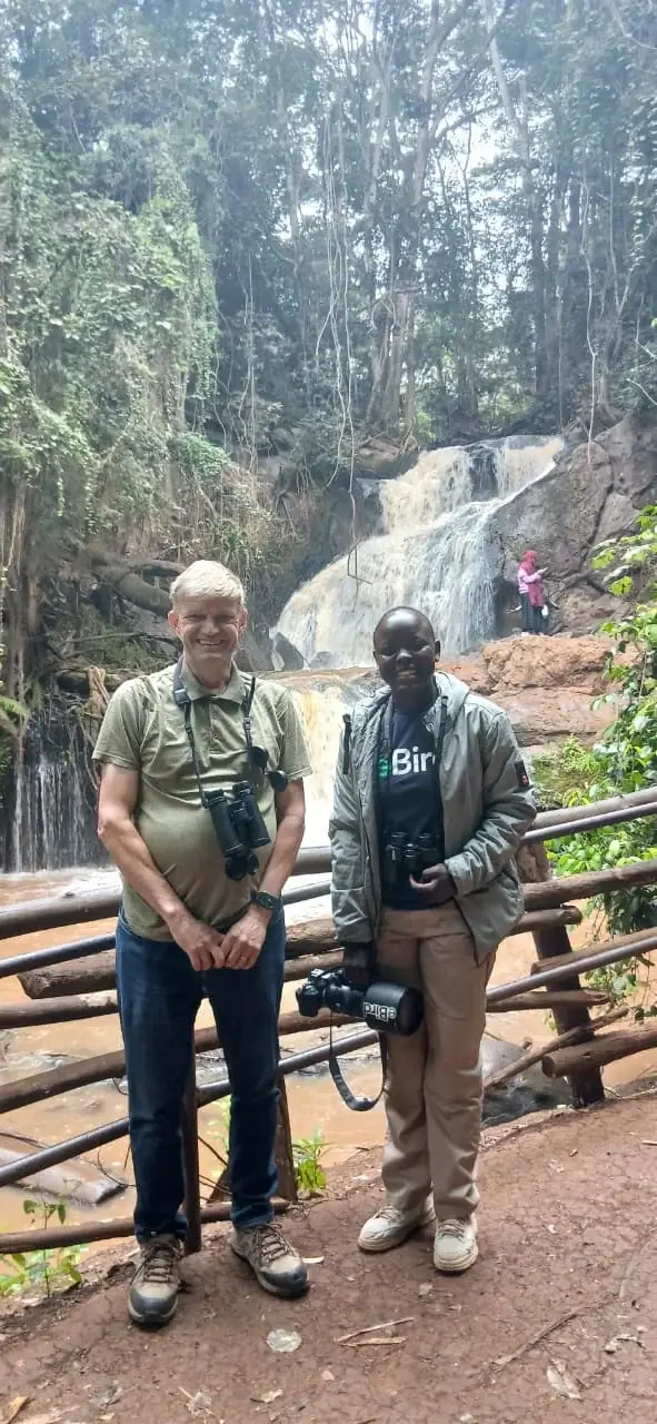 Birding guests enjoying a stop beside a forest waterfall